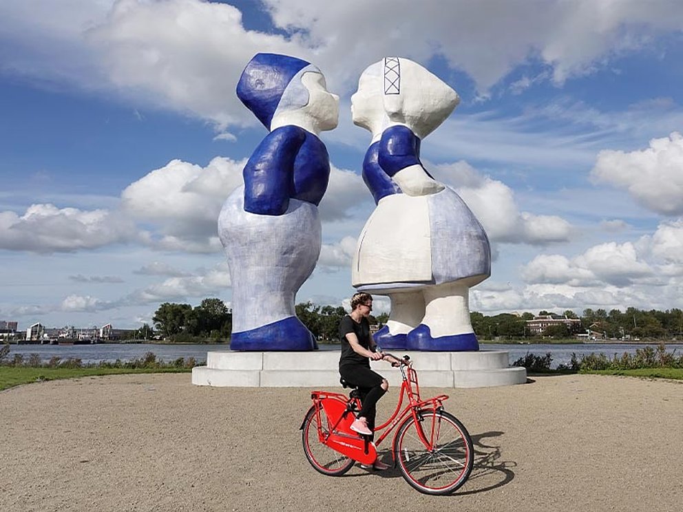 Blue Kissing Couple in Delft, im Vordergrund ein Mann auf einem roten Fahrrad