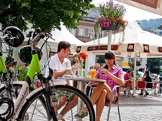 zwei Radfahrer machen Pause bei einem Straßencafe in Judenburg