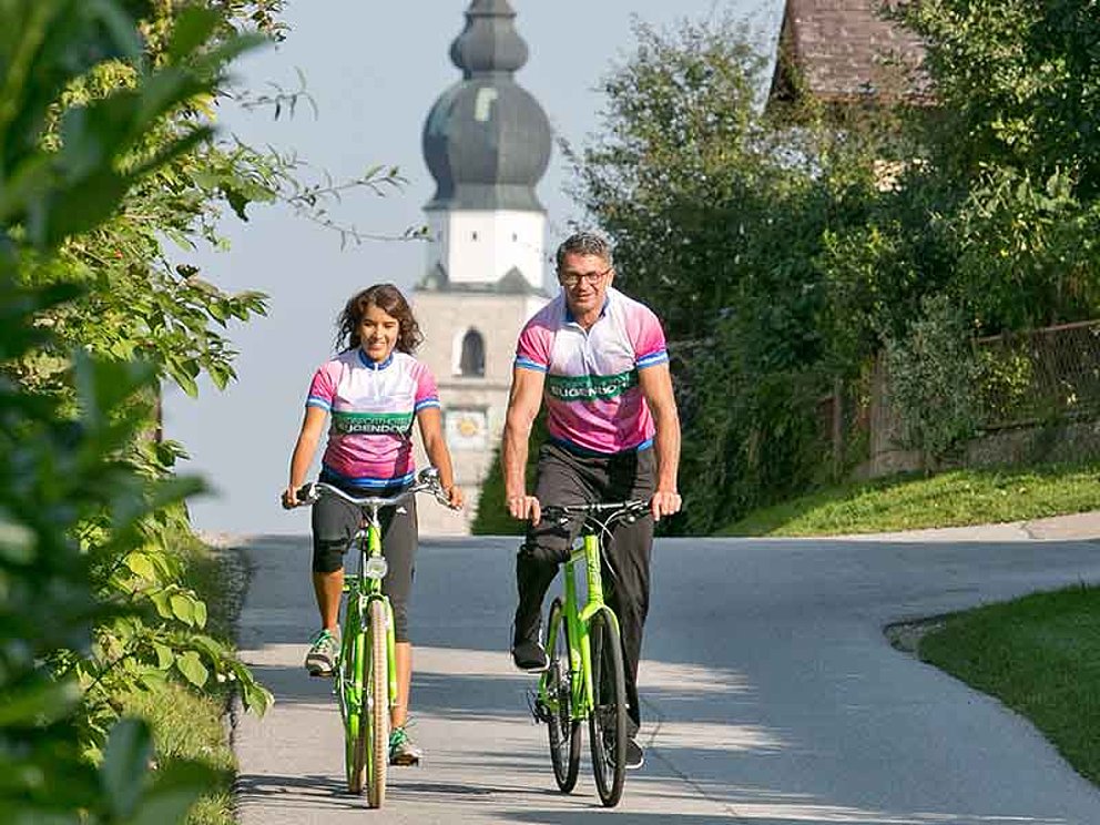 Radfahrer-Paar unterwegs durch den Ort Eugendorf