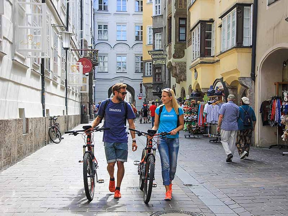Zwei Radfahrer zu Fuß unterwegs in der Altstadt in Innsbruck