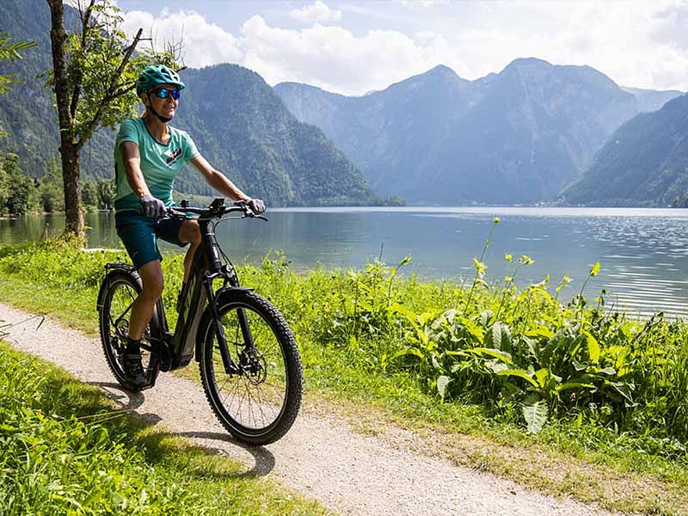 Eine Dame am E-Bike am Ufer des Hallstätter Sees