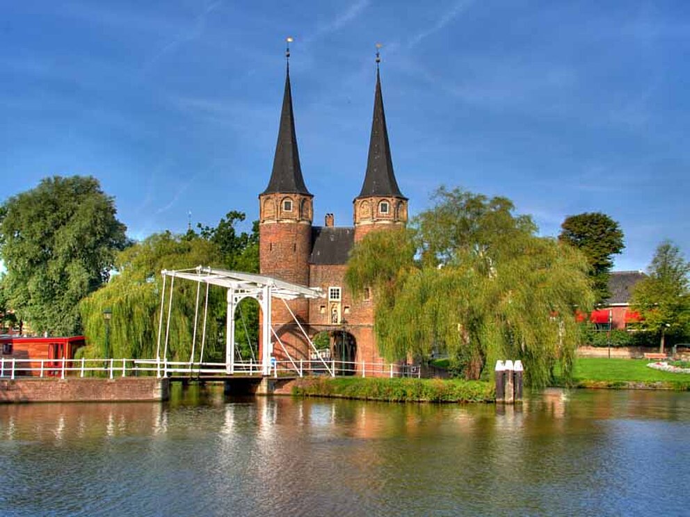 Das Stadttor von Delft befindet sich an einem Fluss, erreichbar über eine Brücke.