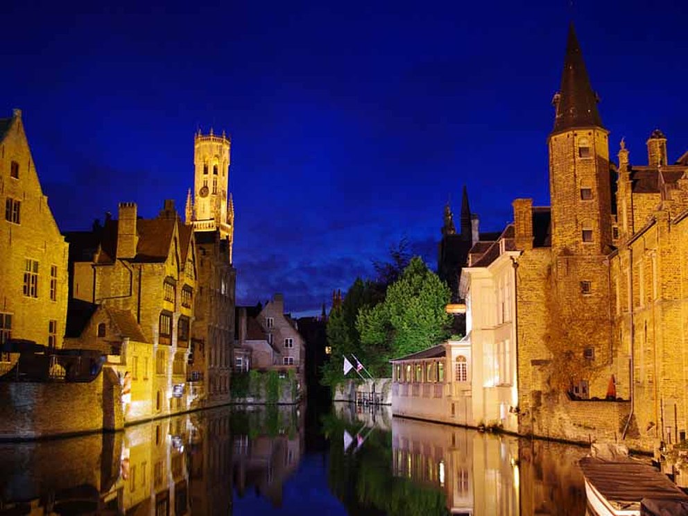 Die Kanäle in Brügge sind in der Nacht beleuchtet. Das Licht gibt den mittelalterlichen Häusern einen märchenhaften Anstrich.