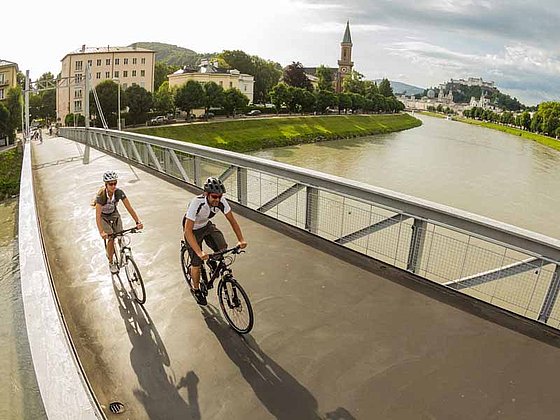 Radeln über die Brücke in Salzburg am Tauernradweg