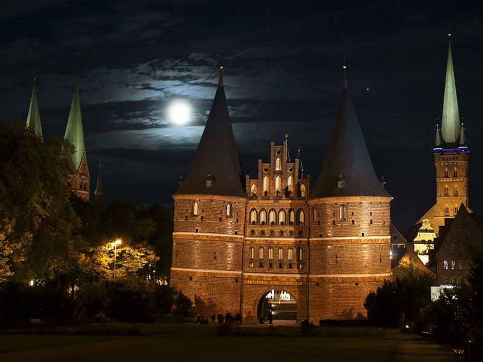 Holstentor bei Nacht im Mondlicht in Lübeck in Deutschland
