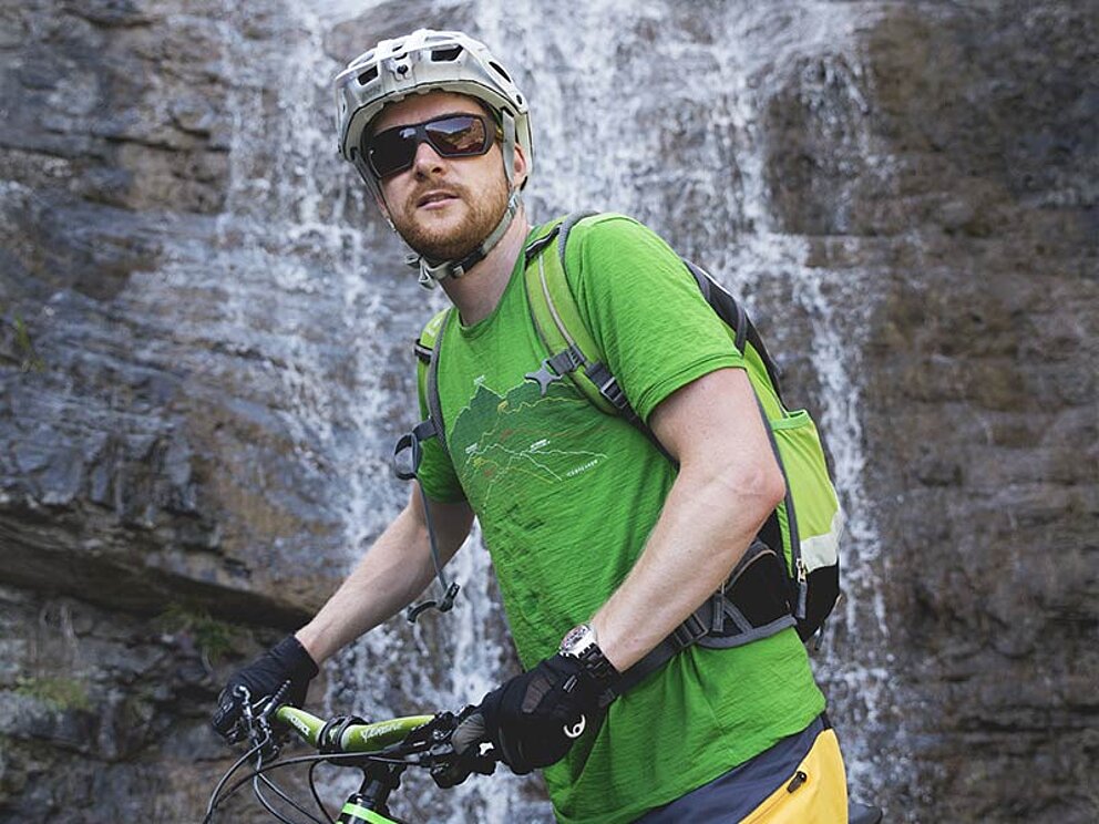 ein Biker vor einem Wasserfall