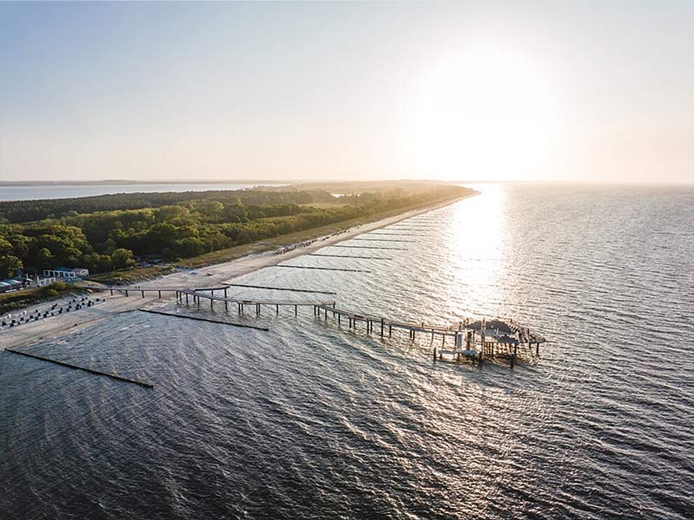 Küste mit Seebrücke im Sonnenuntergang