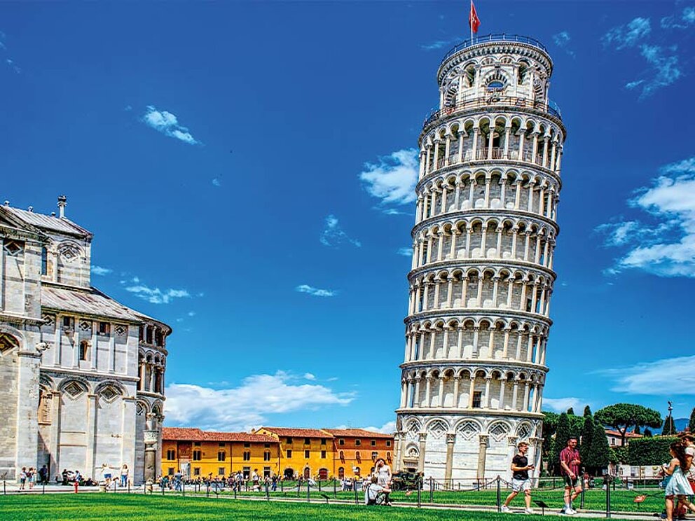 Der schiefe Turm von Pisa und der Dom auf der Piazza dei Miracoli unter strahlend blauem Himmel in Italien.