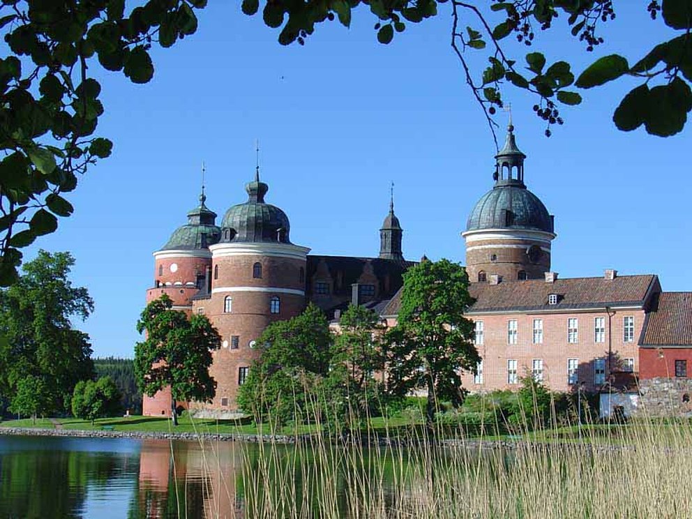 Schloss Gripsholm hat vier Rundtürme und ist von Wasser umgeben.