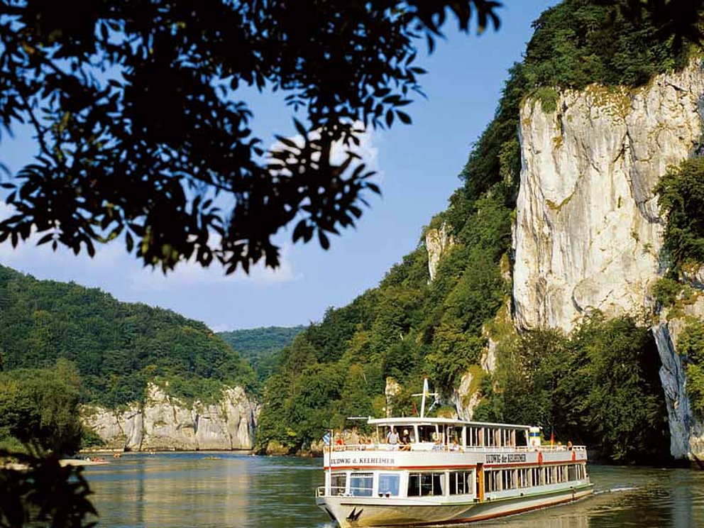 excursion boat passes rough rocks at the Danube at Kelheim