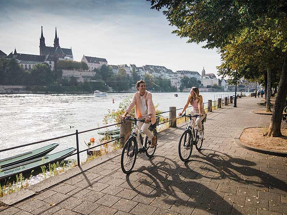 2 Radfahrer an der Uferpromenade des Rheins in Basel