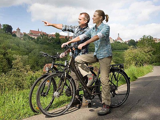Zwei Radfahrer betrachten die Stadt Rothenburg in Deutschland