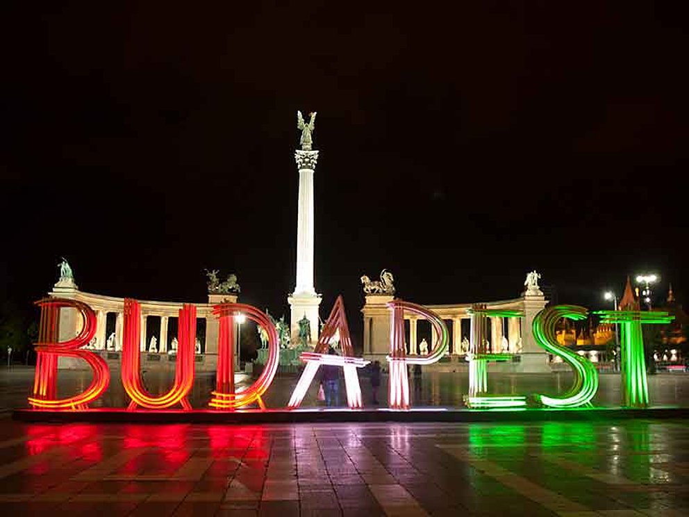Bunter Schriftzug "Budapest" bei Nacht am Heldenplatz