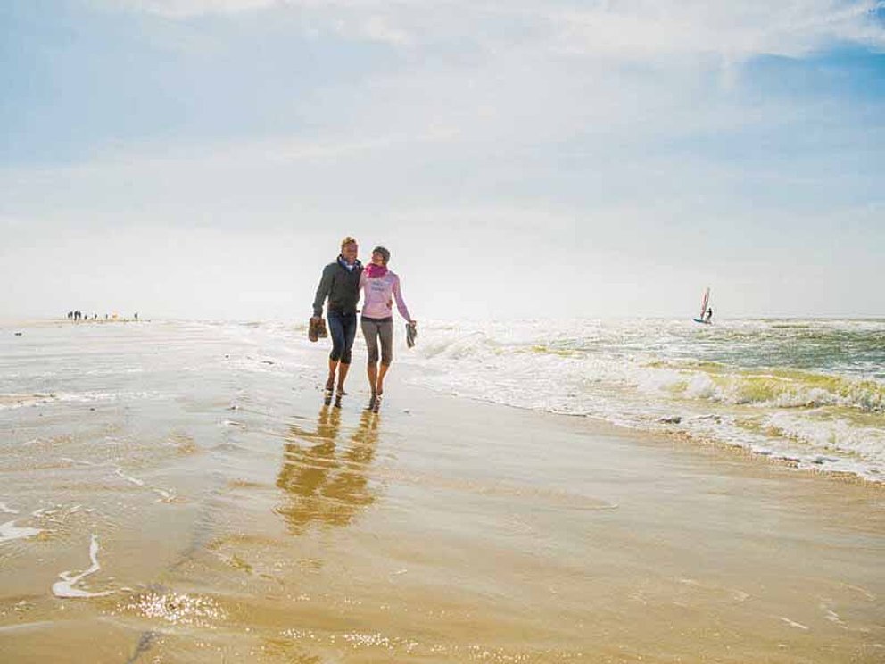 Paar spaziert durchs Wasser am Strand auf der Insel Amrum an der Nordsee
