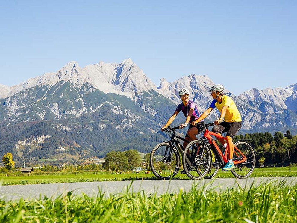 2 Radfahrer mit Alpenkette im Hintergrund