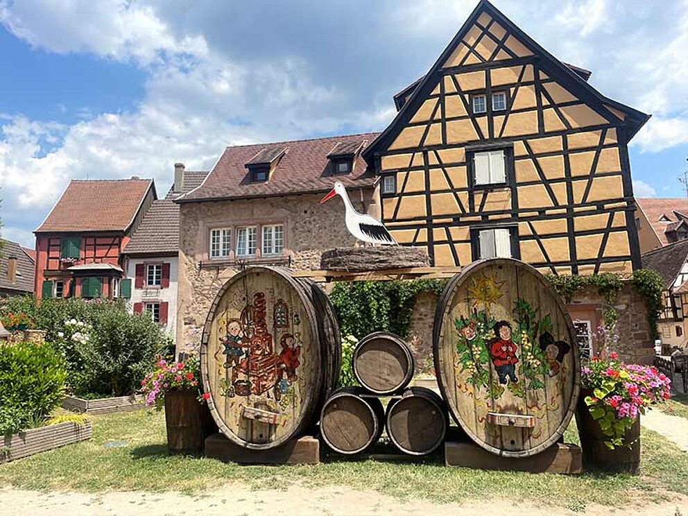 Alte Weinfässer vor einem Haus im Elsass