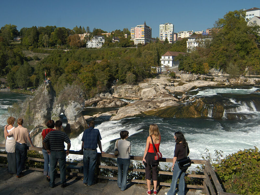 people are watching the Rihine water falls at Schaffhausen