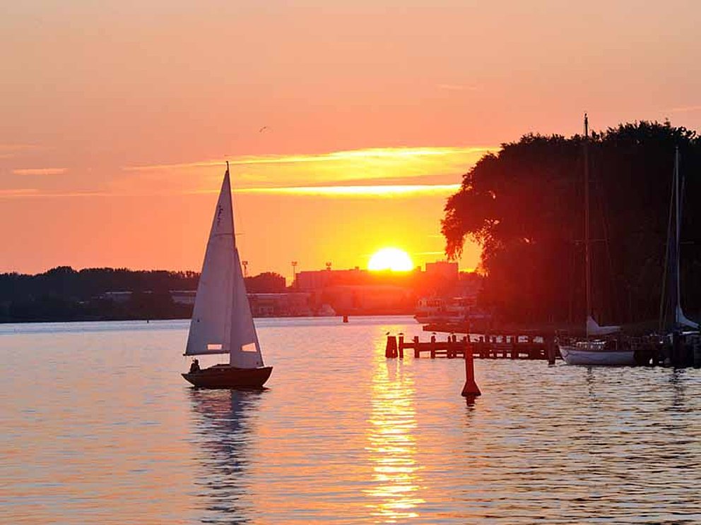 schöner Sonnenuntergang bei Rostock mit Segelboot