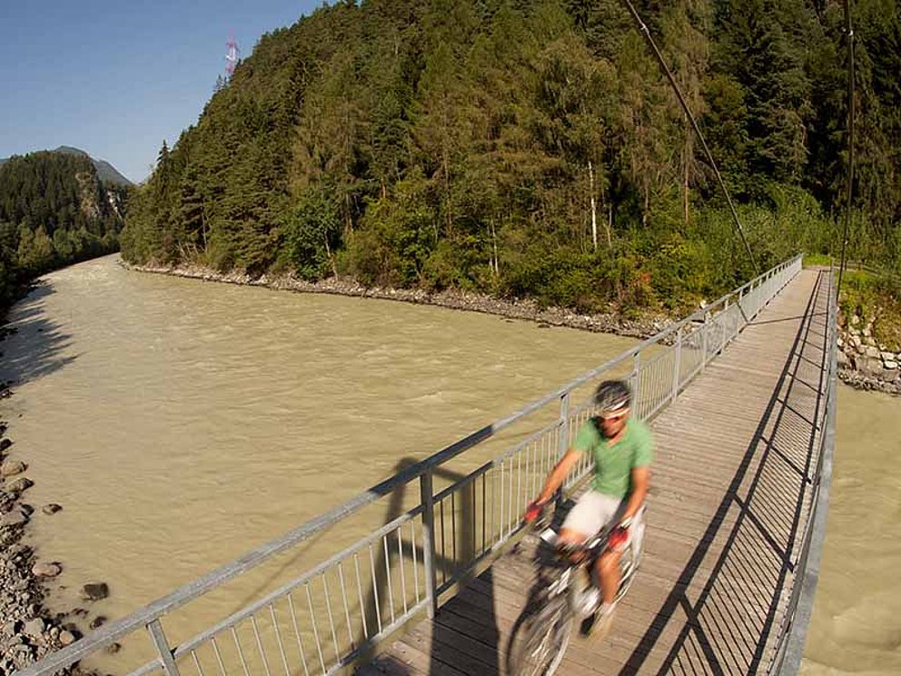 Radfahrer fährt über Innbrücke bei Imst