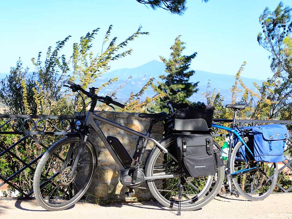 2 Fahrräder mit Packtaschen lehnen an einem Geländer
