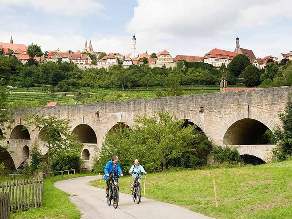 2 cyclists on Altmühltal cycle path, town of Rothenburg in the back