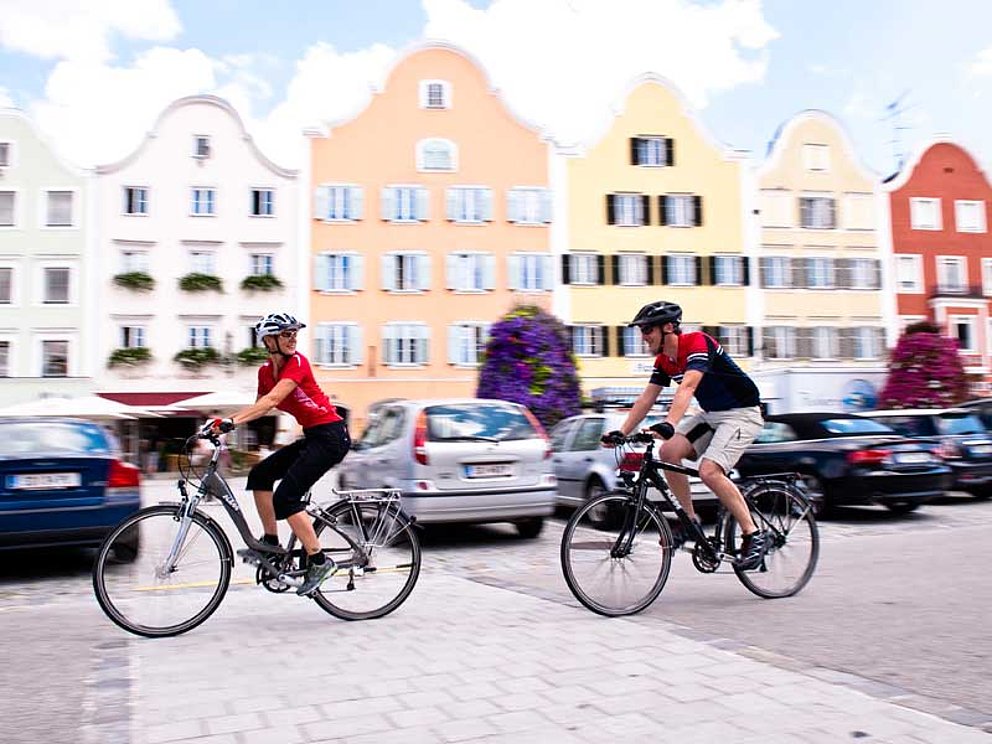zwei Radfahrer unterwegs durch die Stadt Schärding vorbei an der Silberzeile