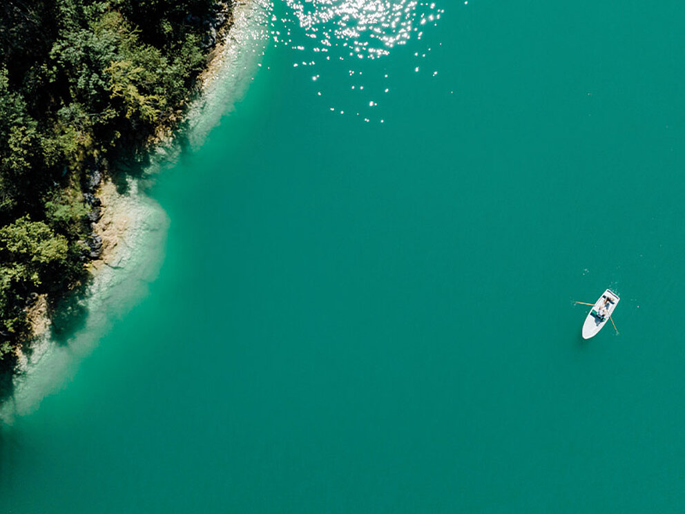 Ein Ruderboot am türkisblauen Wolfgangsee von Oben