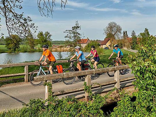 4 Radfahrer überqueren eine Brücke über die Altmühl