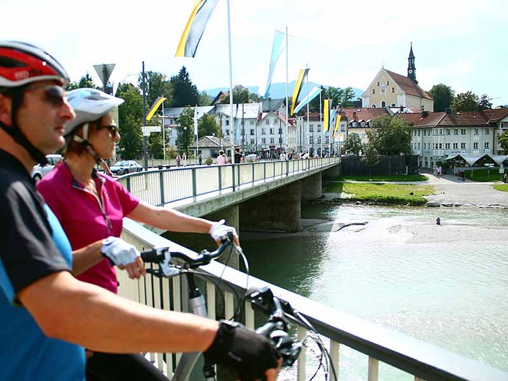 zwei Radfahrer bewundern die Isar von Brücke in Bad Tölz in Deutschland
