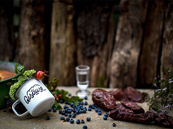 Cup, sausages, bread, schnapps and berries on a wooden table