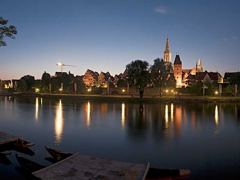 Blick von anderem Ufer der Donau auf beleuchtetes Ulm bei Nacht