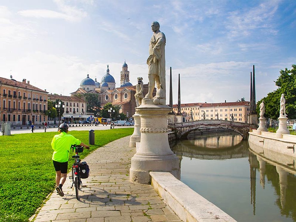 Ein Radfahrer schiebt sein Rad in Padua
