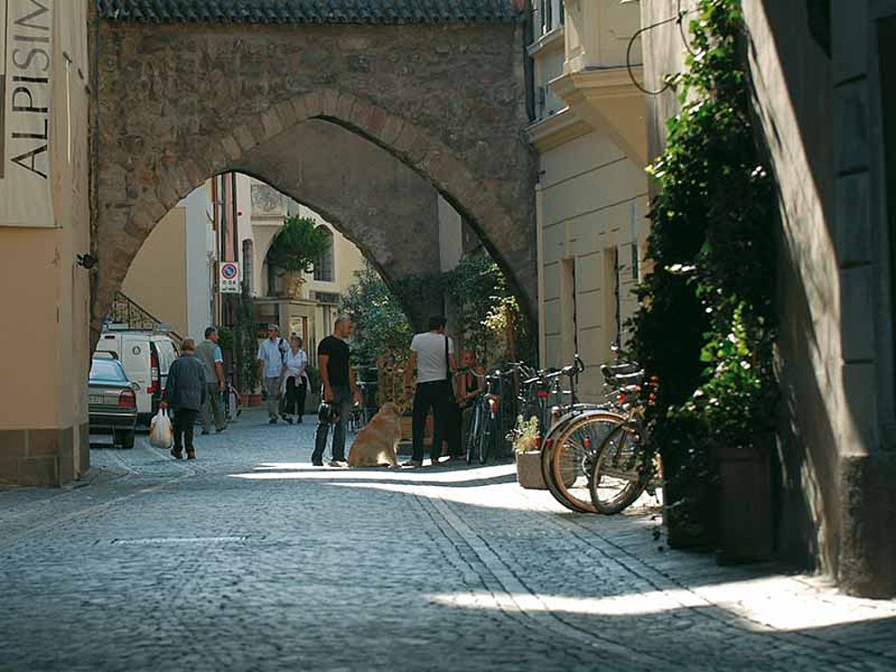 Altstadt in Bozen mit alten Mauern und Menschen
