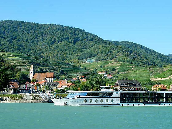 Blick über die Donau auf Spitz mit vorbeifahrender MS Primadonna