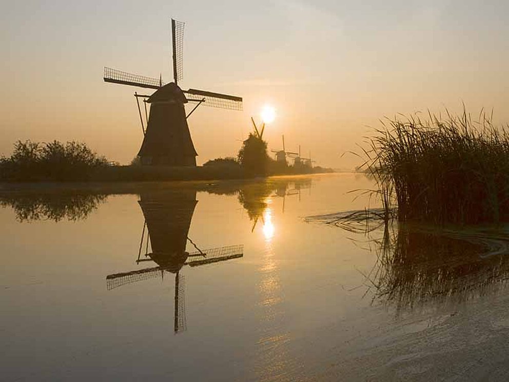 Wasser-Windmühle bei Sonnenaufgang in Kinderdijk in den Niederlanden