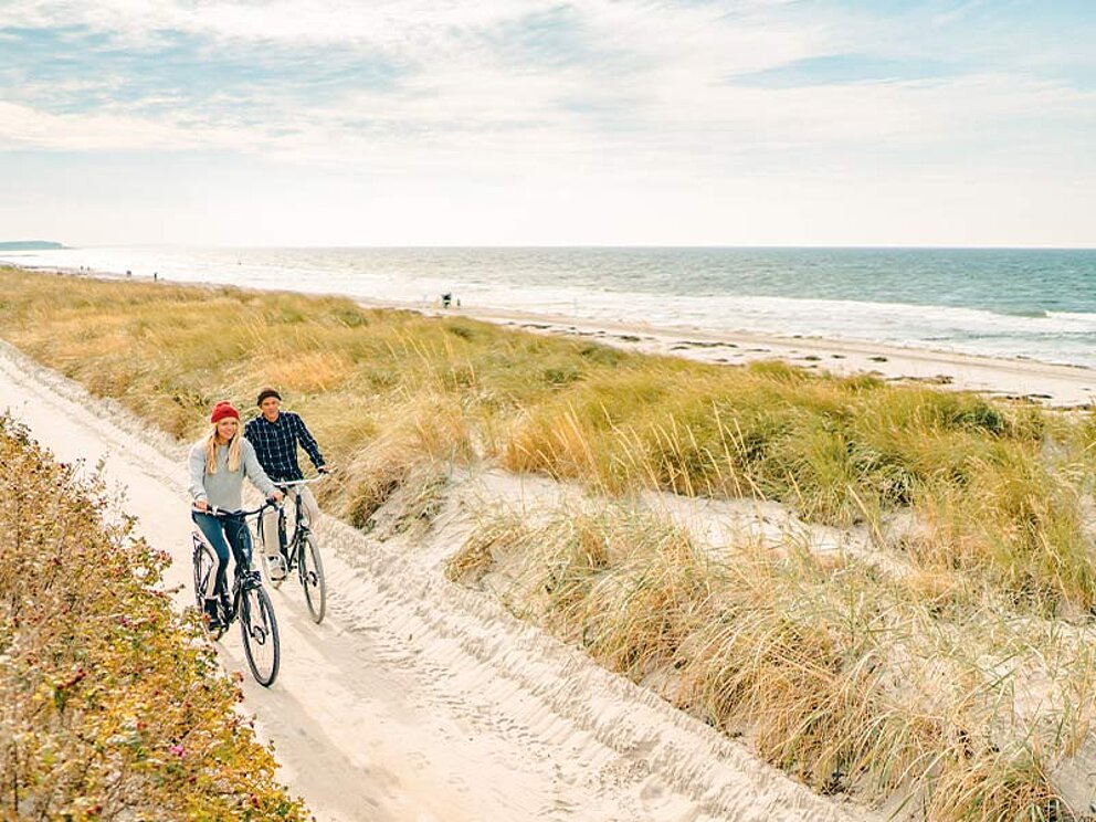 2 Radfahrer am sandigen Radweg an der Ostseeküste