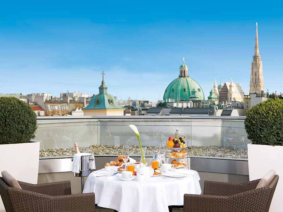 gedeckter Frühstückstisch auf der Dachterrasse im Hotel Herrenhof in Wien mit Blick auf den Stephansdom.