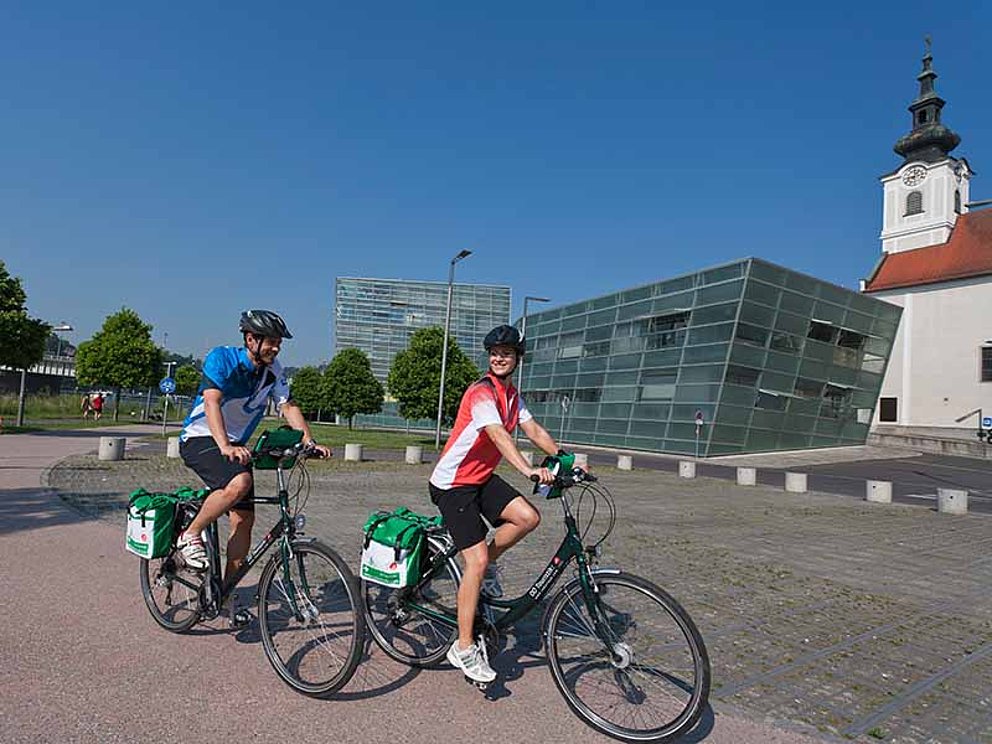 Zwei Radfahrer unterwegs am Donauradweg in Linz